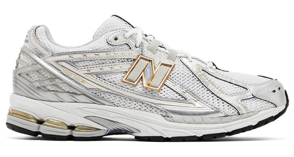 White athletic shoe with gold accents on a white background