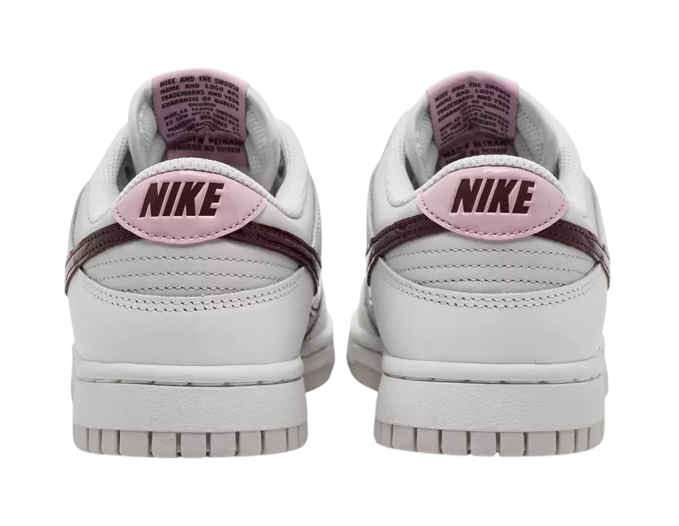 White Nike sneakers with pink swoosh logo on a white background